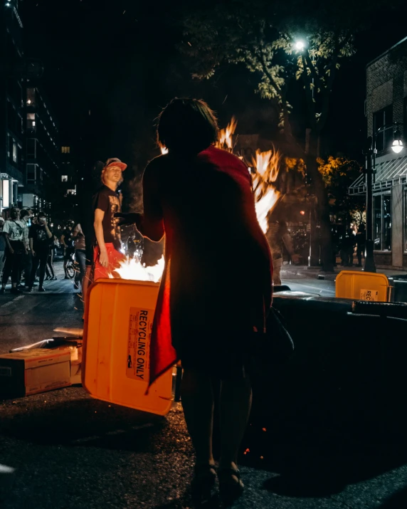 a woman holding a fire pit and looking at the flame