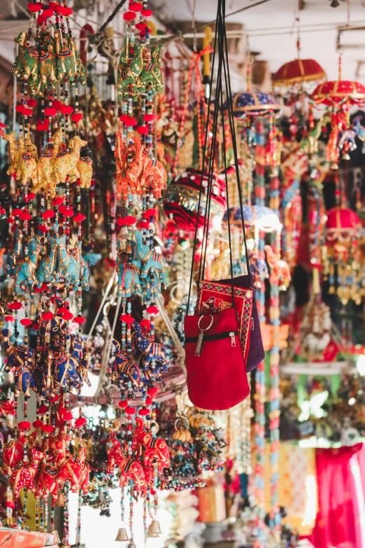 an assortment of colorful beaded necklaces hanging from a ceiling