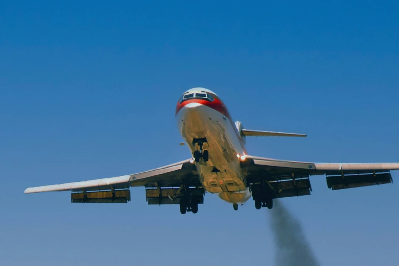 an airplane with its landing gear off releasing fuel