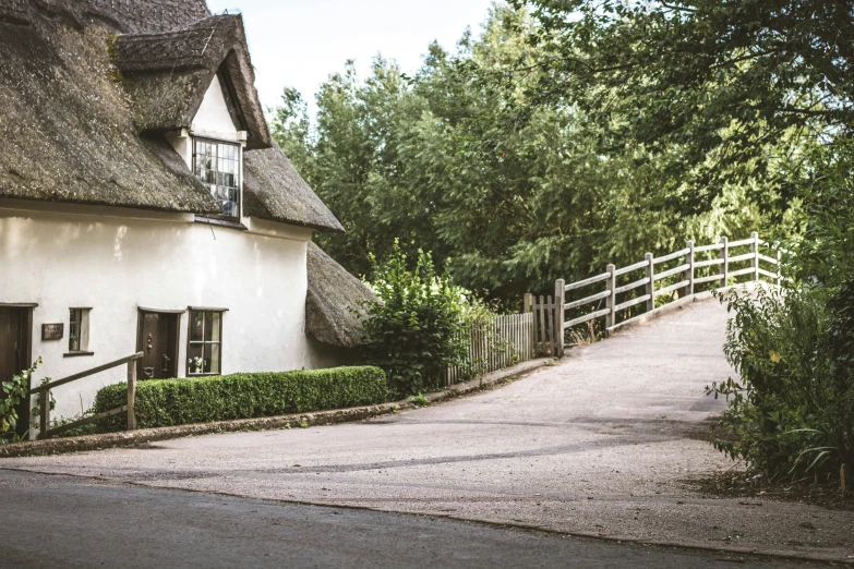 an old style house has a gate and thatched roof