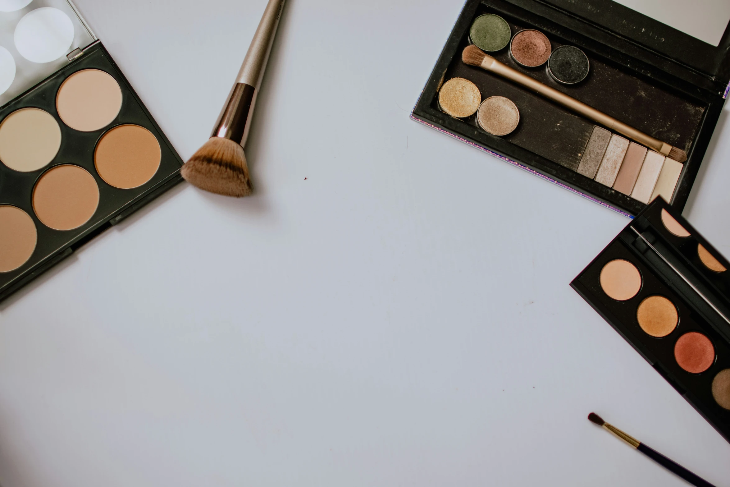 a table with makeup brushes and other beauty products on it