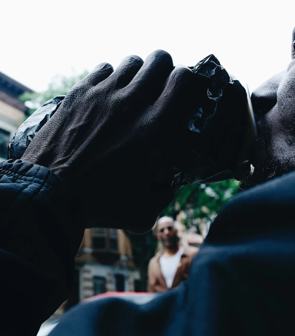 a man is wearing black gloves while he looks into the camera