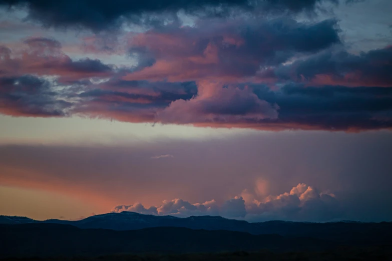 the clouds are purple with sun rays peeking through