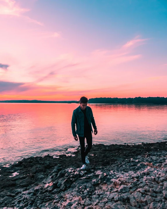 a man is standing near a body of water