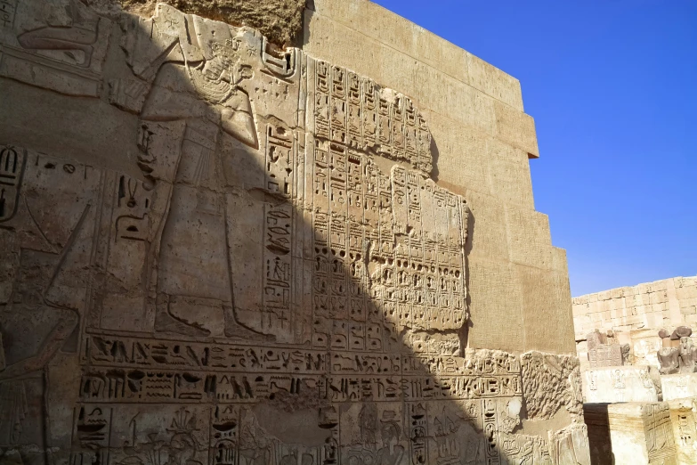 an ancient sculpture in front of some stone walls