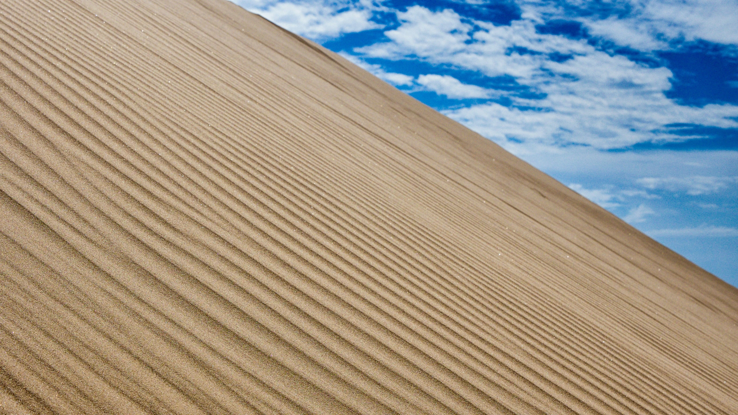 the sky above the sand dunes is very blue