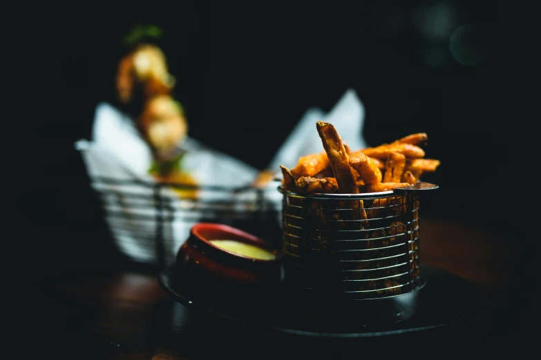 baskets with french fries and dipping sauces on a table