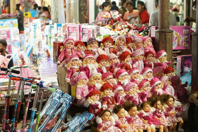 there are many dolls on display near a bicycle