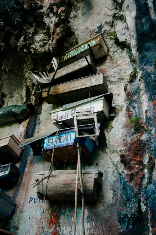 several boats laying on the side of a cliff with graffiti