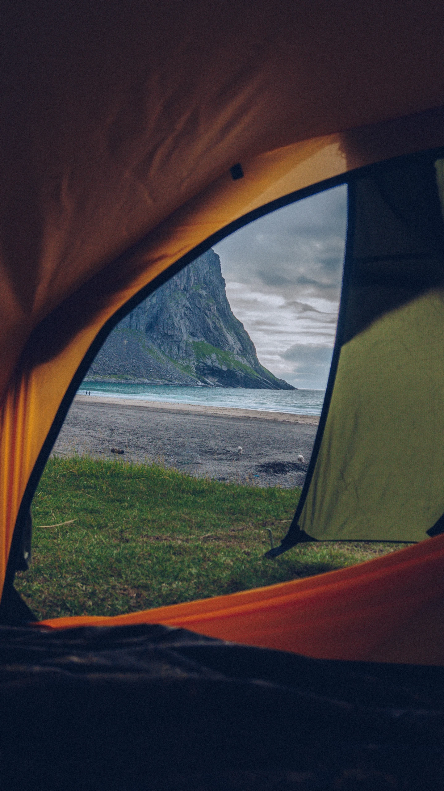 a green tent with the view of a mountain from inside it