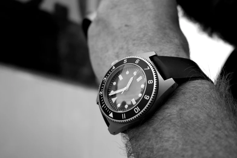 a watch on a man's arm, with dark celets