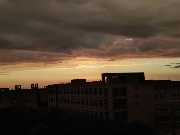 a sunset view from high up with a very tall building in the distance