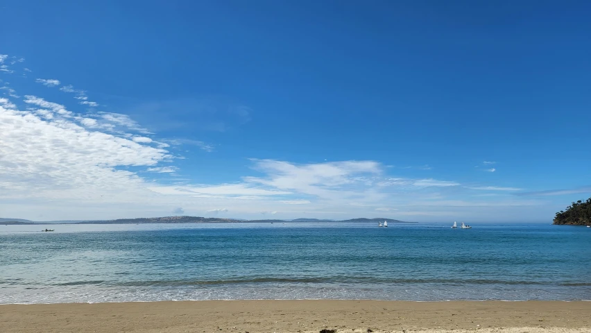 a beach next to an island and water