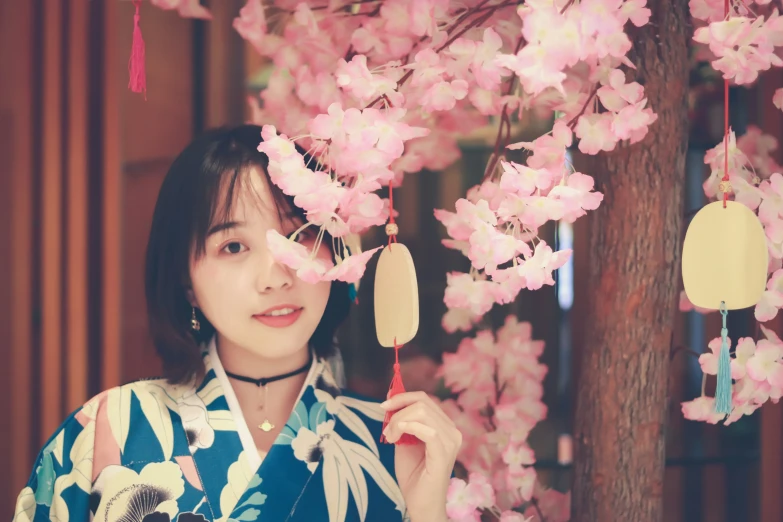 a woman standing under some cherry blossom trees