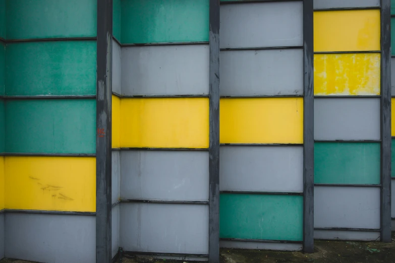 a couple of windows sitting under a yellow and green wall