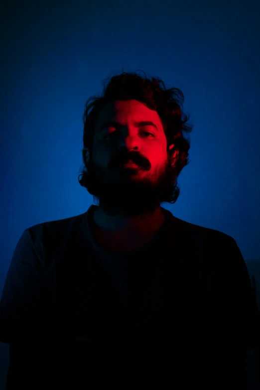 a bearded man with a beard in a dark room