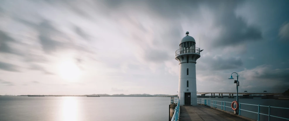 a light house sitting on the end of a pier