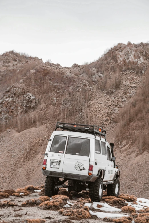 an off road vehicle driving along side a rocky hill