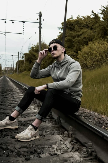 the man is sitting on the railroad track