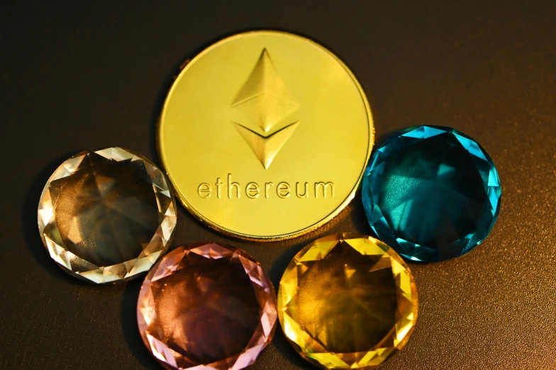 five different colored gems on a table near a gold coin