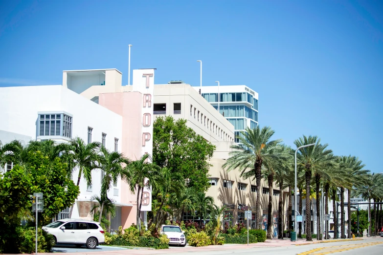 a long view of a large, colorful building with trees and cars parked