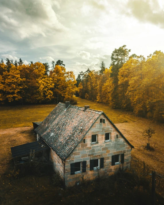 an abandoned brick house with a broken tin roof and window