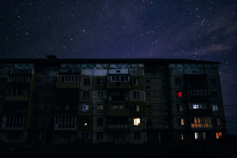 night time scene with a tall building and stars in the sky
