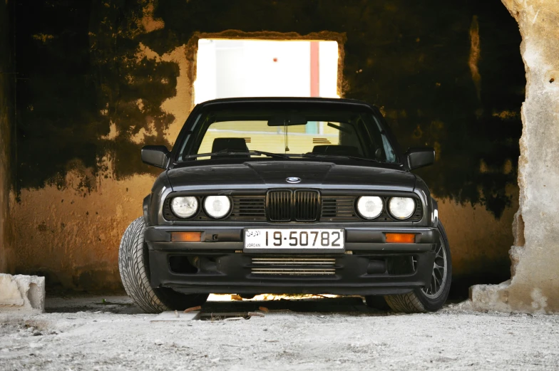 a black car parked in a tunnel next to a wall