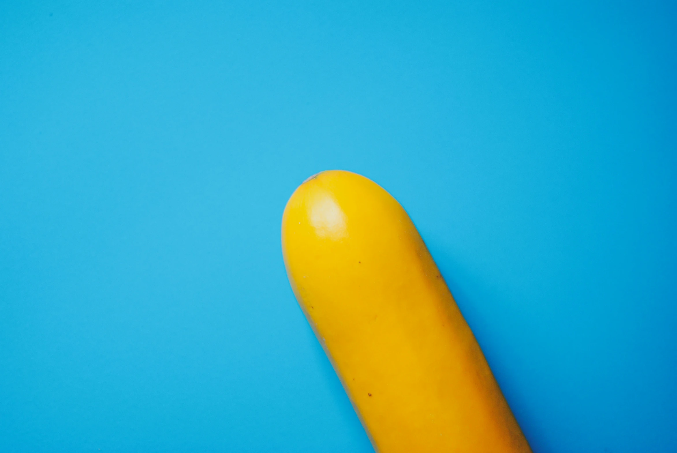 a yellow object is posed on a blue background