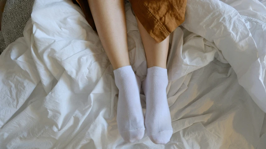 a person laying in bed with her feet on a pillow