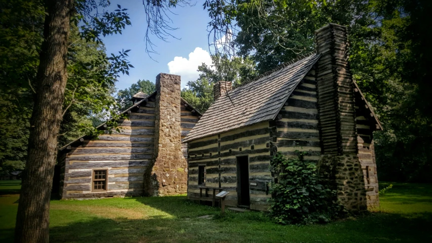 an old log house on a farm surrounded by trees