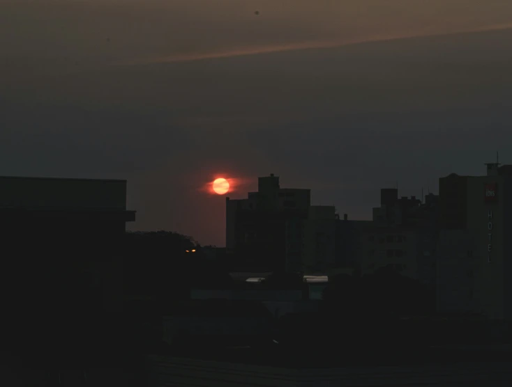 the sun peeking through the clouds of a city