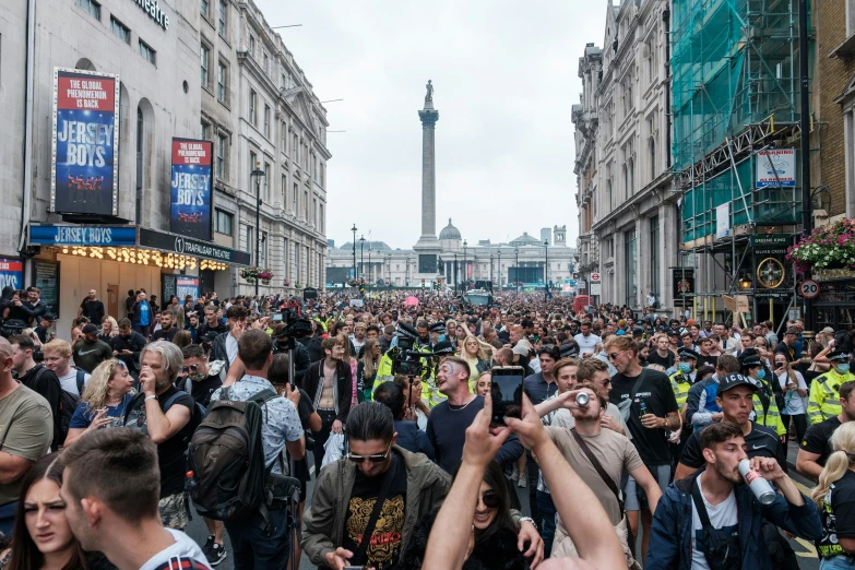 a crowded street filled with people walking through the city