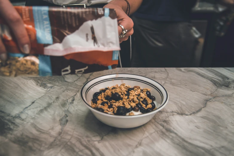 a bowl full of cereal sits next to the bag on the table