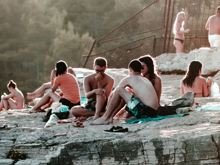 a group of people sitting on a sandy beach