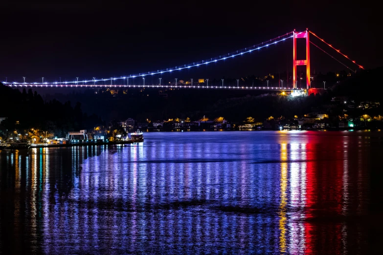 a view of the bay bridge lit up in red, white and blue at night