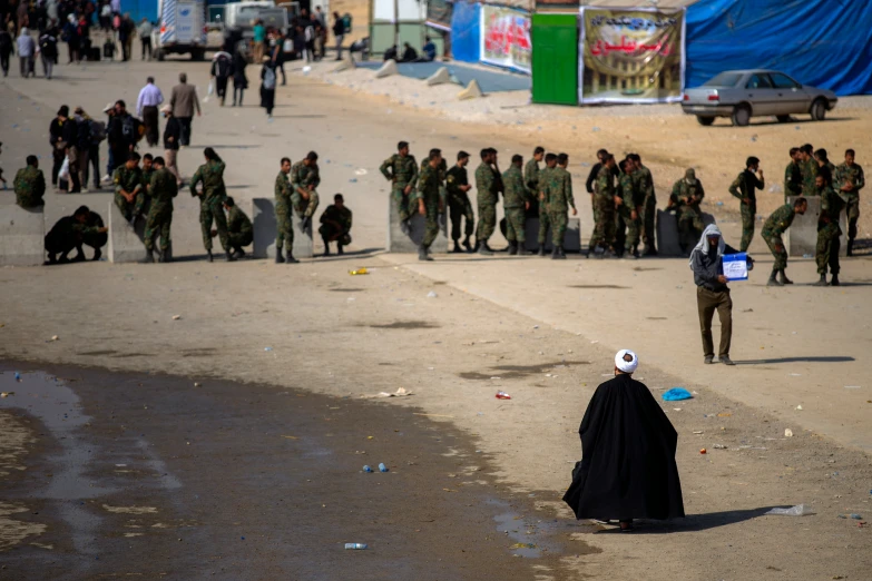 a man dressed as a ghost is in front of army personnel