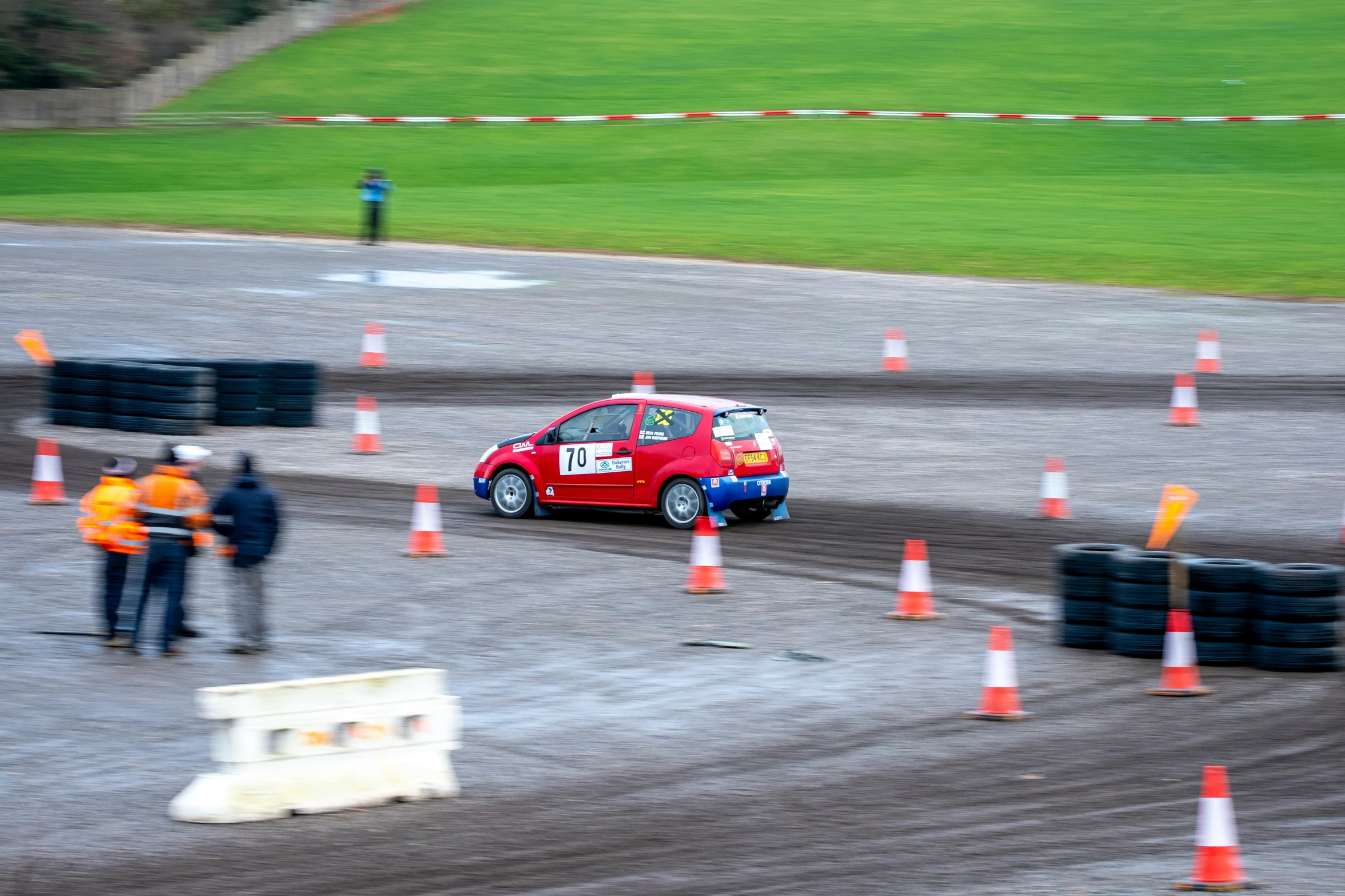 there is a red mini truck on the track with safety cones