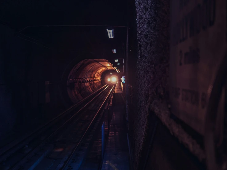 a dark and dimly lit tunnel with people on it