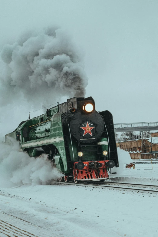 a train traveling through the snowy countryside on top of snow covered tracks