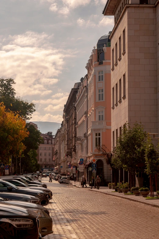 a street with parked cars and tall buildings