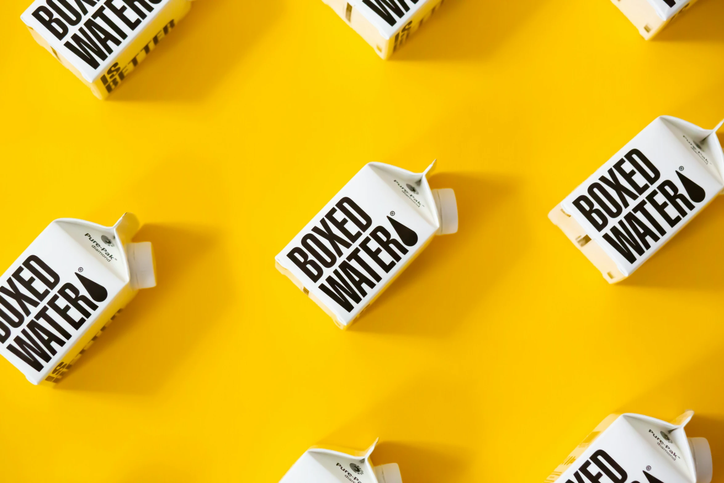 several milk cartons are laying side by side on a yellow background