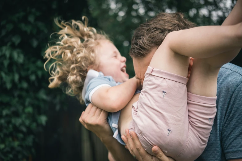 there is a little child with its head on a woman's shoulder