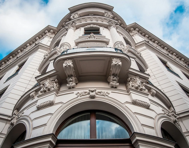 the corner of an arched building with windows and trim