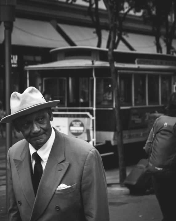 a man in a suit and tie standing on the side walk