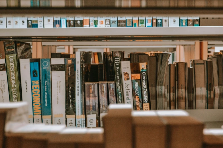 a book shelf filled with lots of books and brown boxes