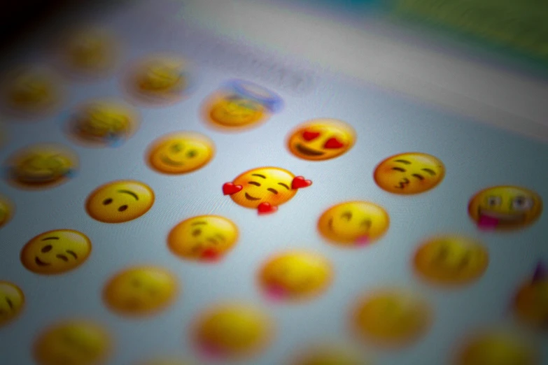 an old computer monitor displays several smiley face icons