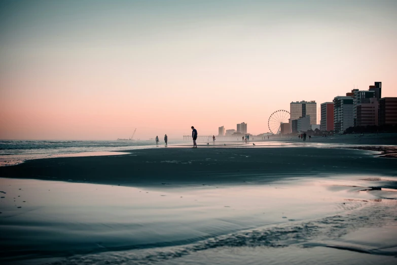 silhouettes in the background as the sun sets over the ocean