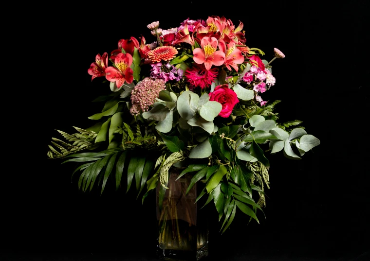 colorful flowers in a vase against a black background