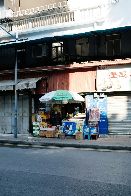 an outdoor market place with a table and umbrella